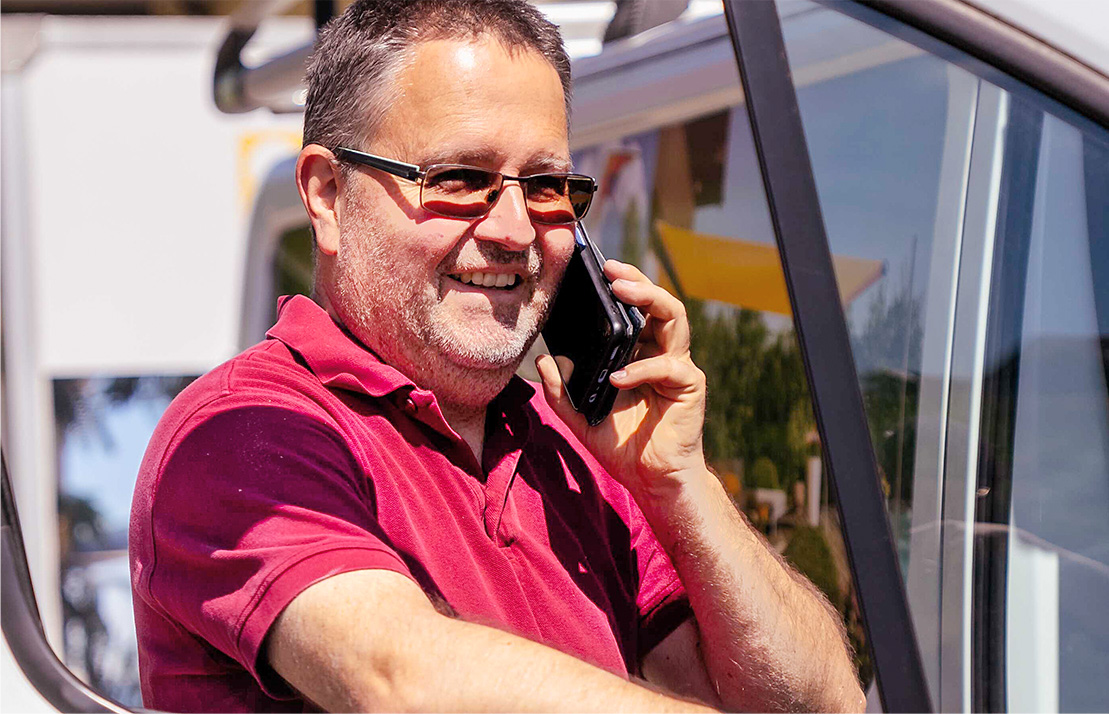 Mann mit rotem Oberteil telefoniert